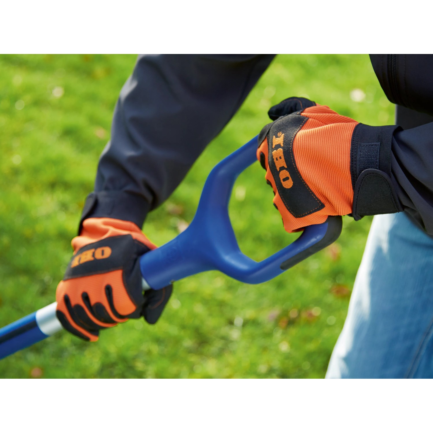 Hände mit OBI Arbeitshandschuhen (Größe 10) halten einen blauen Spaten. Gartenbekleidung für sicheren Griff.