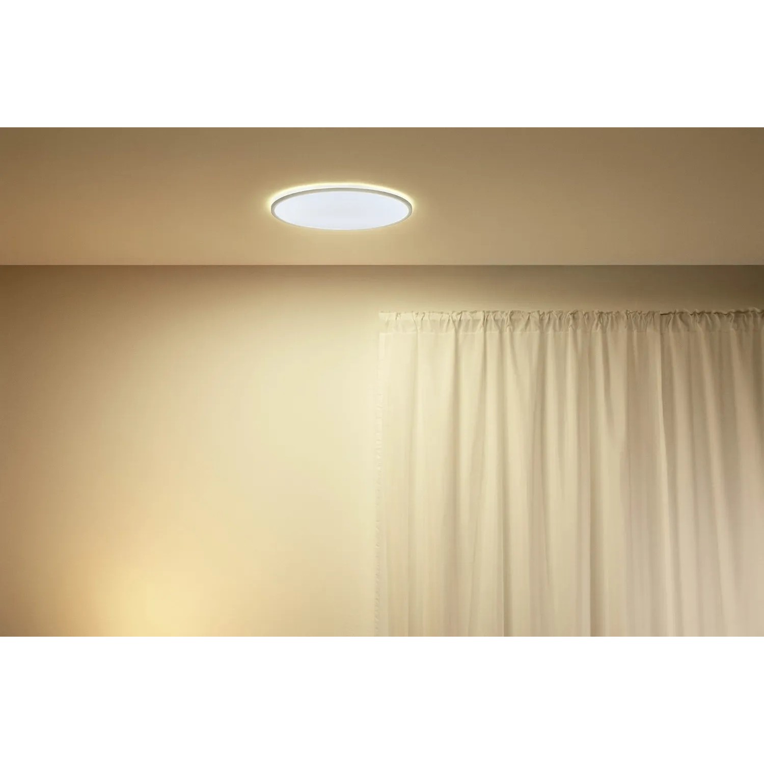 Weiße, runde WiZ LED-Deckenleuchte SuperSlim mit warmweißem Licht an der Decke.