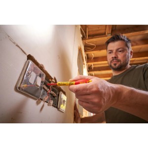 Mann benutzt isolierten Stanley Fatmax Schlitz Schraubendreher an einer Steckdose.