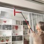 Frau reinigt Fenster mit Vileda Profi-Fensterwischer-Set mit Stiel. Reinigungsgerät für streifenfreie Sauberkeit.