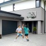 Salta Basketballbrett Center mit zwei spielenden Personen vor Hauswand.