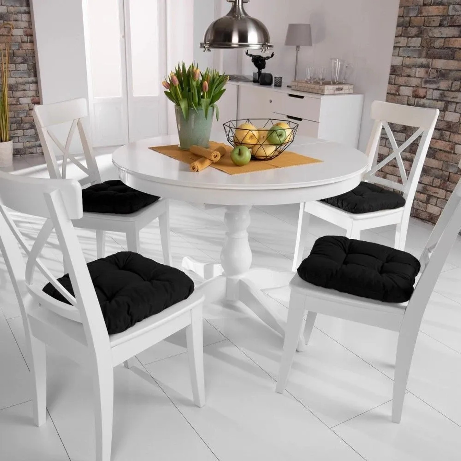 Vier schwarze Beautissu Lisa Stuhlkissen 40x40cm mit Steppung auf weißen Stühlen am Esstisch für Komfort.