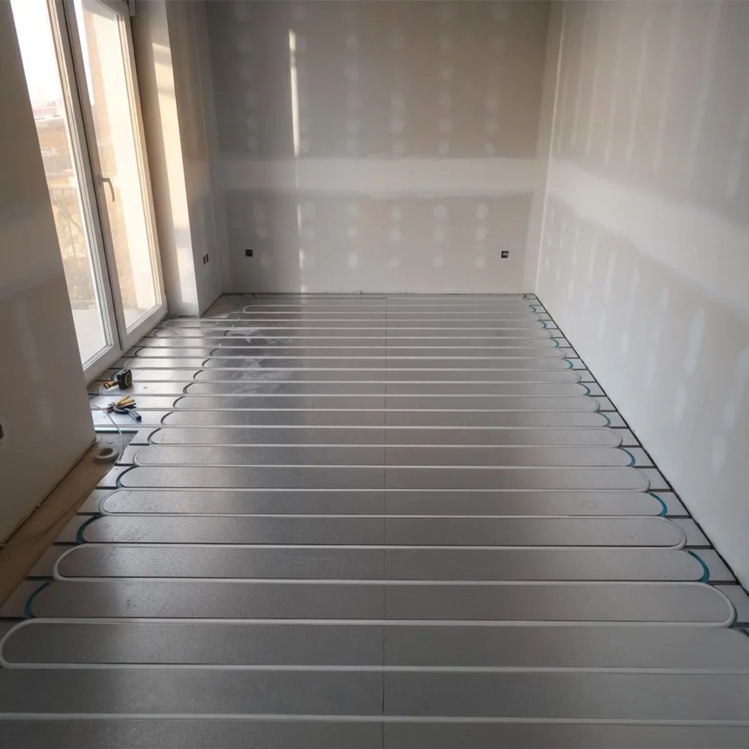 Verlegtes Belvit Fußbodenheizung Set 45 m² Trockenbau mit Metallverbundrohr im Raum.