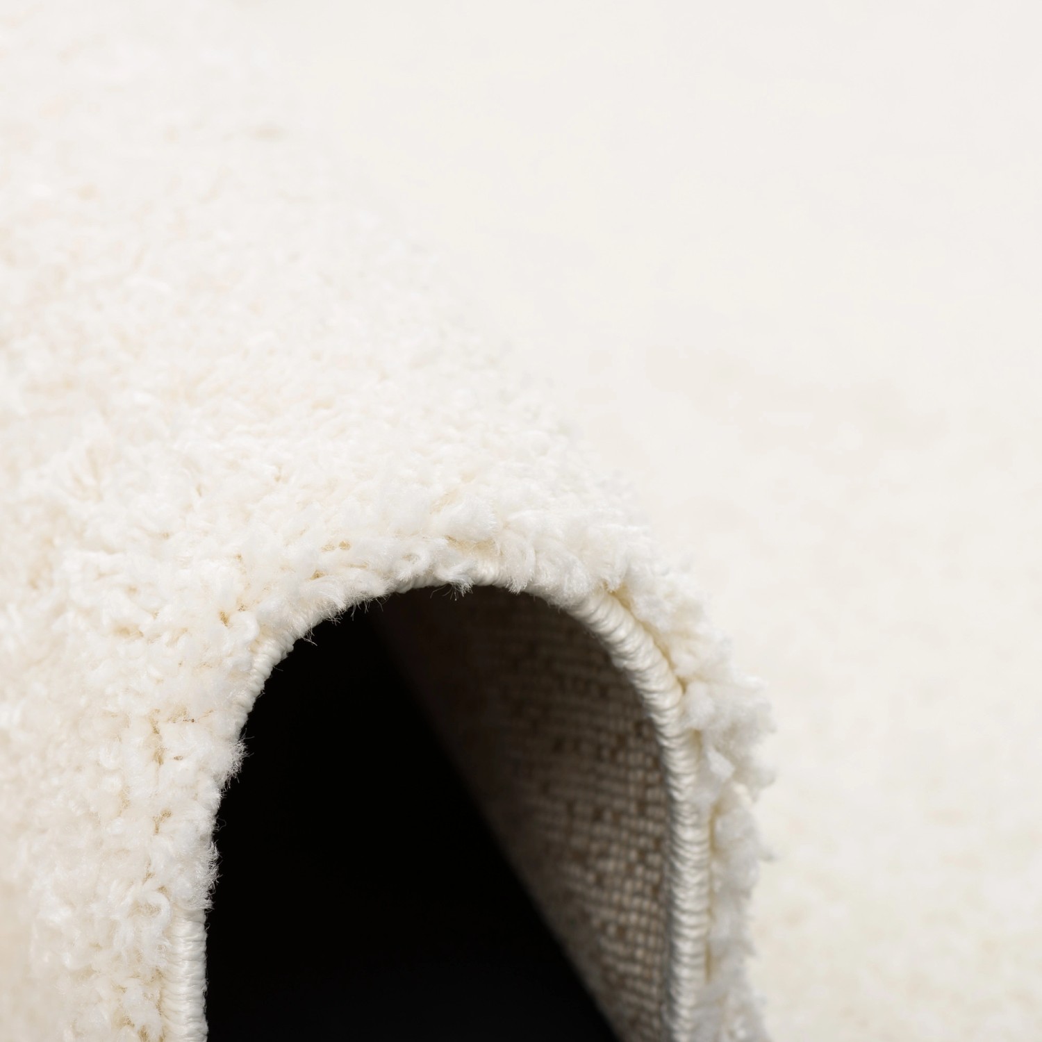 Detailaufnahme: Weißer, runder Langflor Teppich Aloha (120cm) mit weicher Textur.