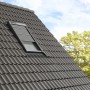 Velux Hitzeschutz-Markise Schwarz am Dachfenster, teilweise geöffnet.