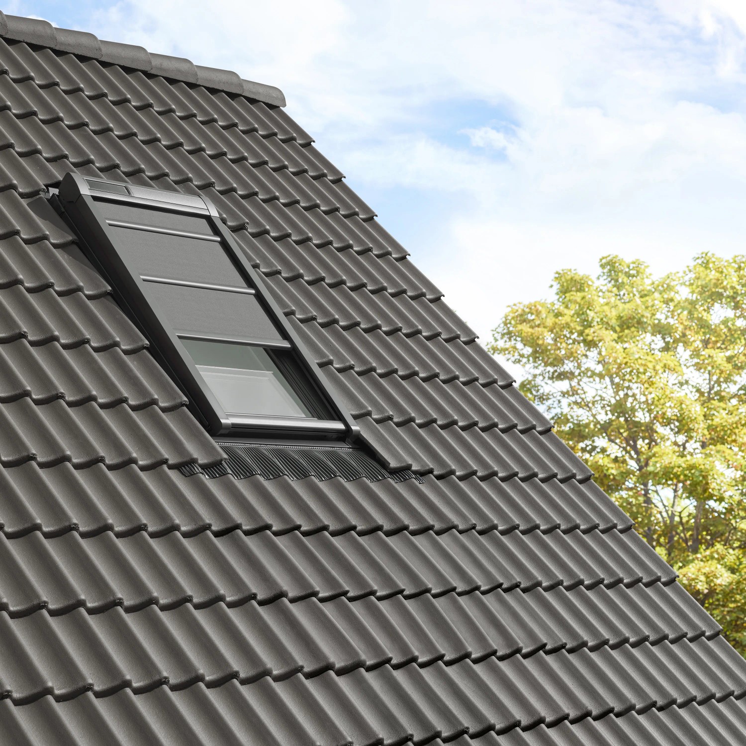 Velux Hitzeschutz-Markise Schwarz am Dachfenster, teilweise geöffnet.
