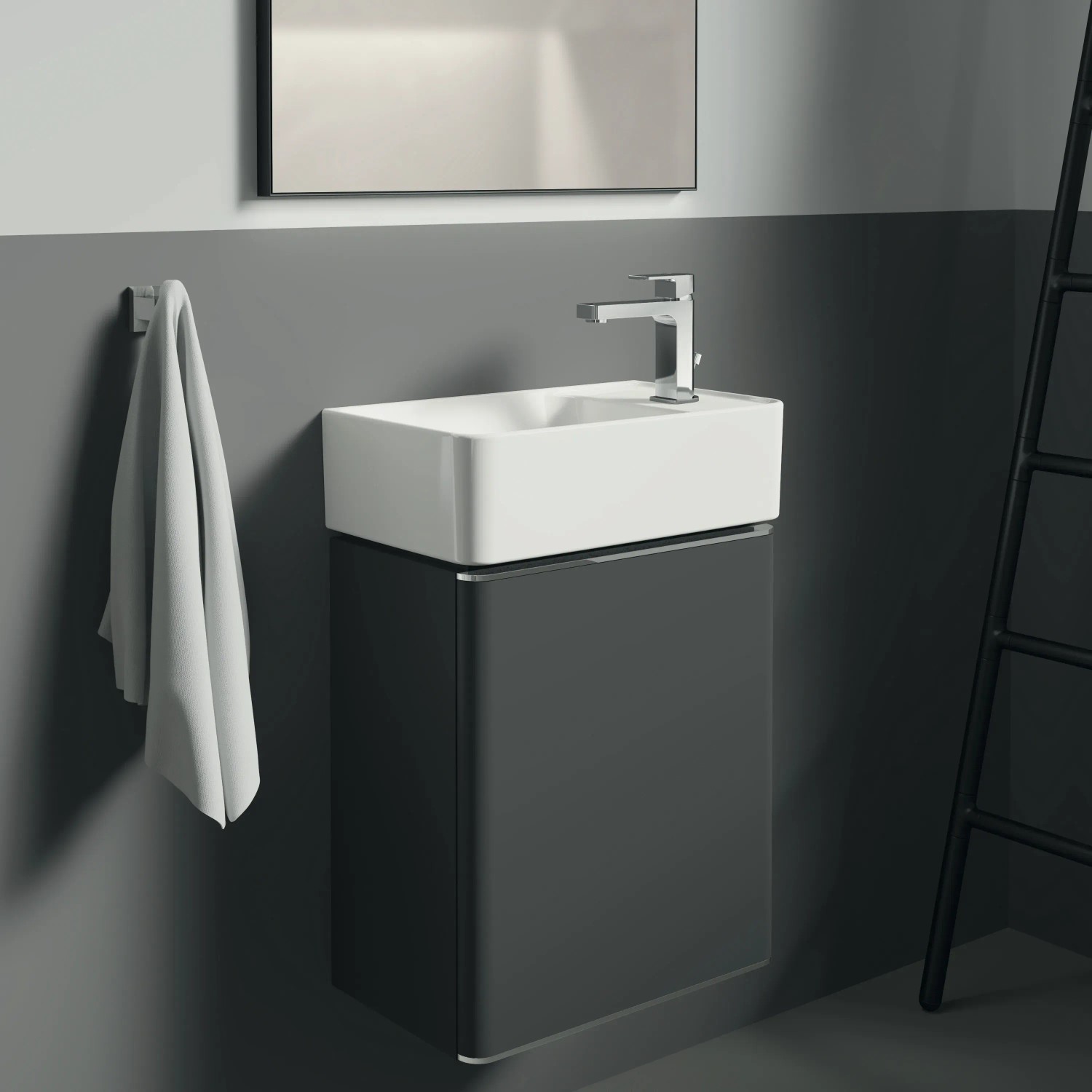 Ideal Standard IOM Cube Handtuchhaken in Chrom an grauer Wand mit Waschbecken und Handtuch.
