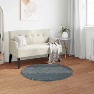 Runder vidaXL Kunstfell Teppich Olite in Anthrazit, Ø 120 cm, aus weichem Polyester, auf Holzfußboden im Wohnzimmer.