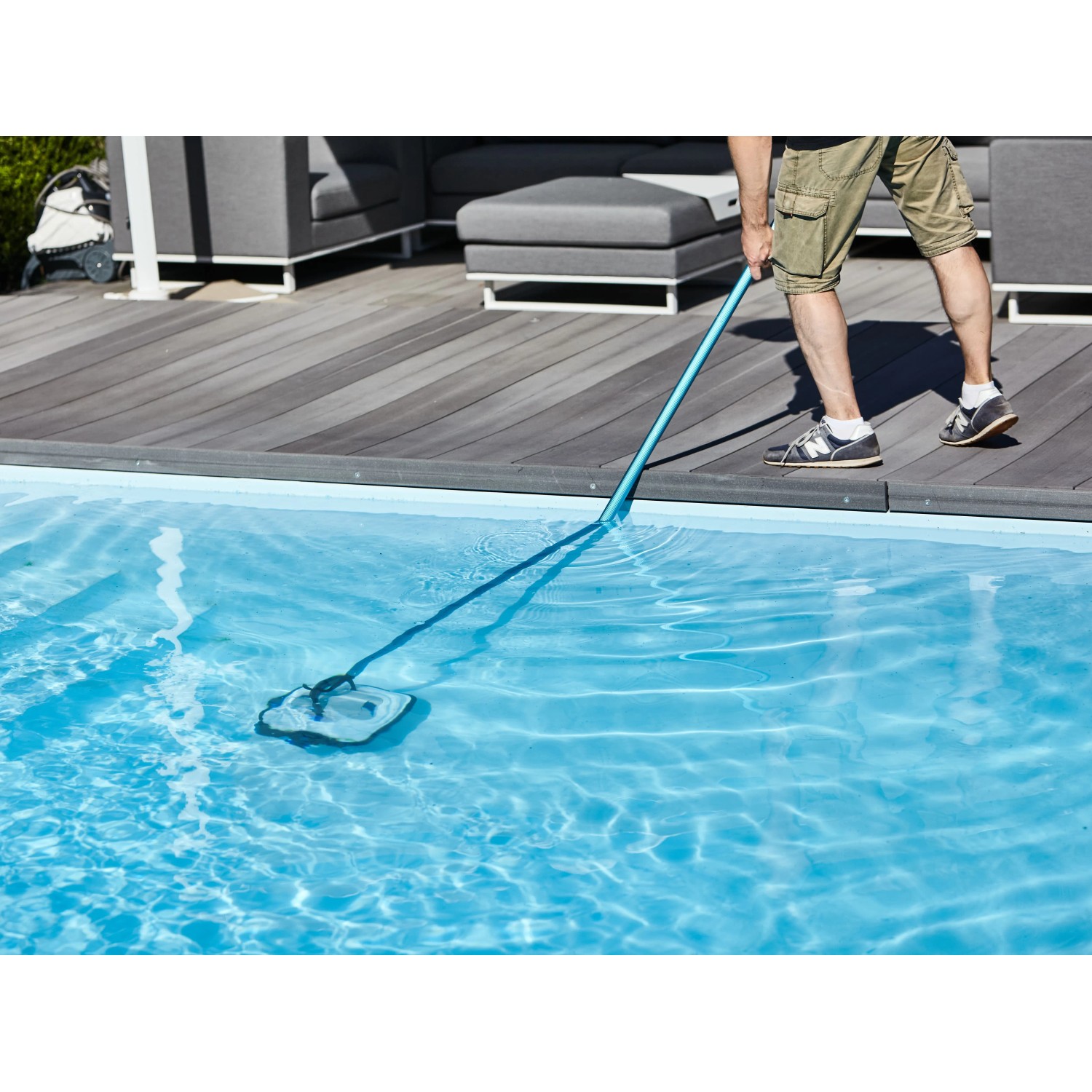 Mann reinigt Pool mit Akku-Poolroboter Orca 45 CL. Der Poolroboter ist blau und hat eine Bürste.