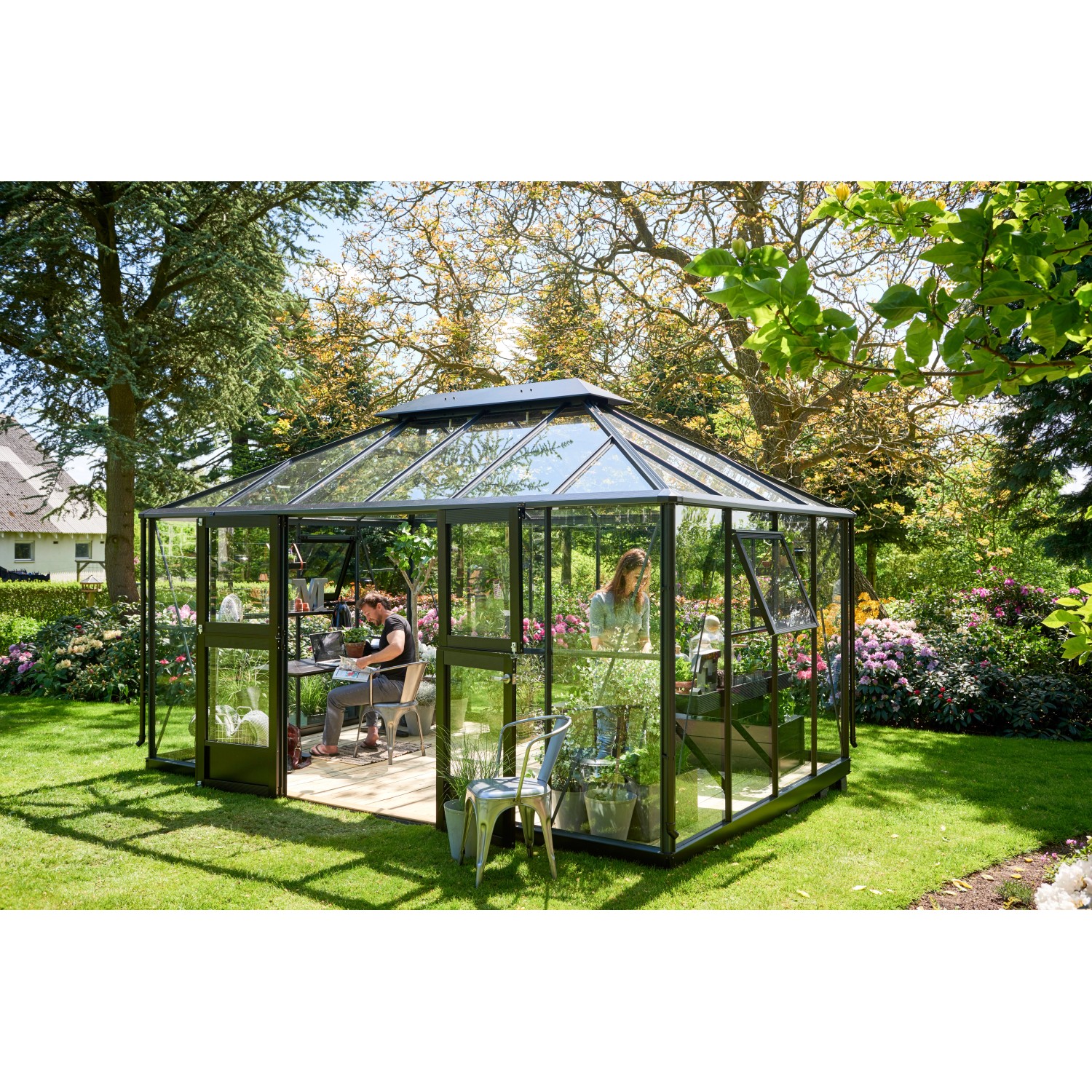 Juliana Gewächshaus Grand Oase 13 Anthrazit, 13 m², mit Personen im Garten.