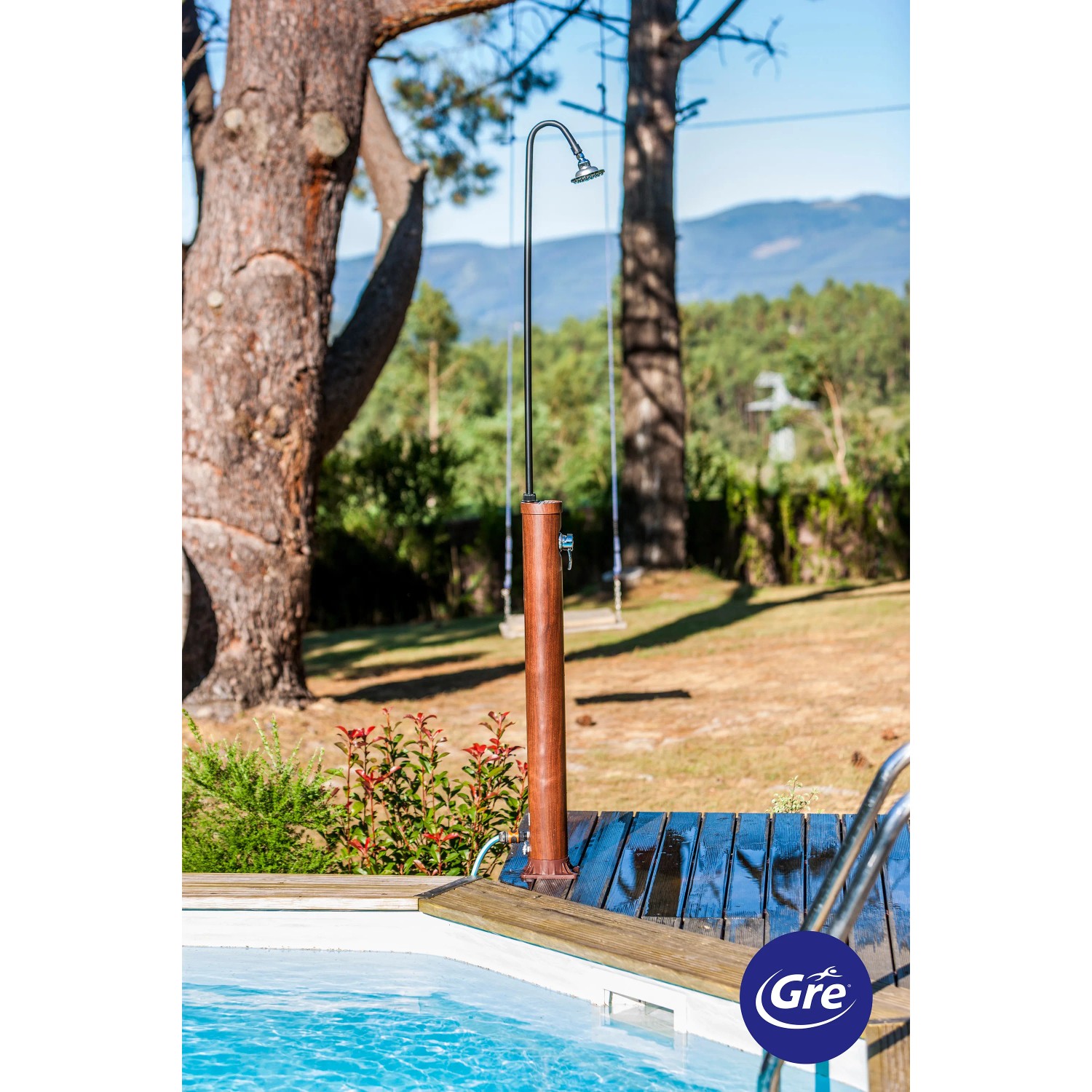 Gre Solardusche in Holzoptik (9 l) neben Pool im Garten.