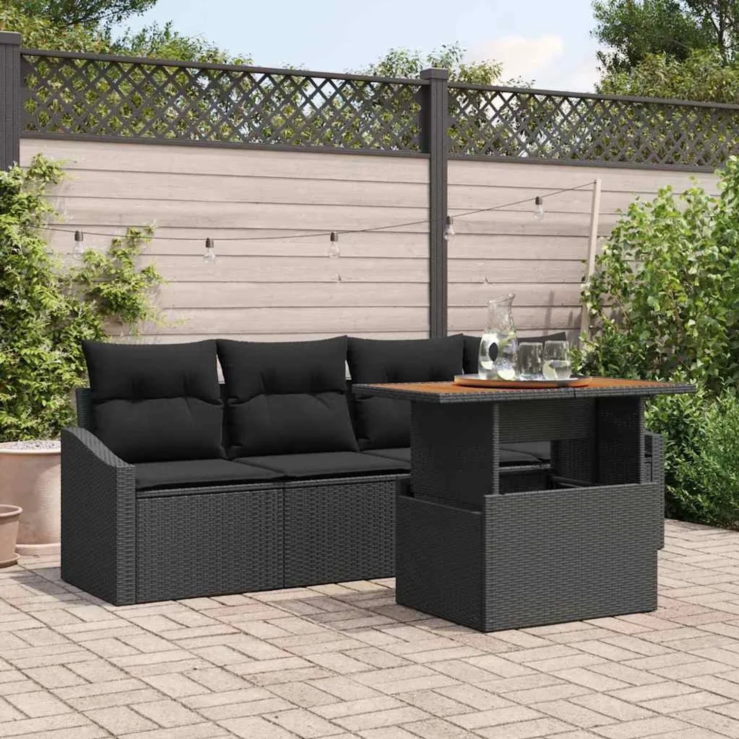 Schwarzes 5-teiliges Garten-Sofa-Set aus Poly Rattan mit Tisch und Kissen.