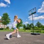 Mädchen beim Basketballspielen mit dem Salta Basketballständer Dribble im Garten.