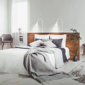 Bett mit zwei weißen, schwenkbaren Briloner LED Bettleuchten Tuso als Nachttischlampen.