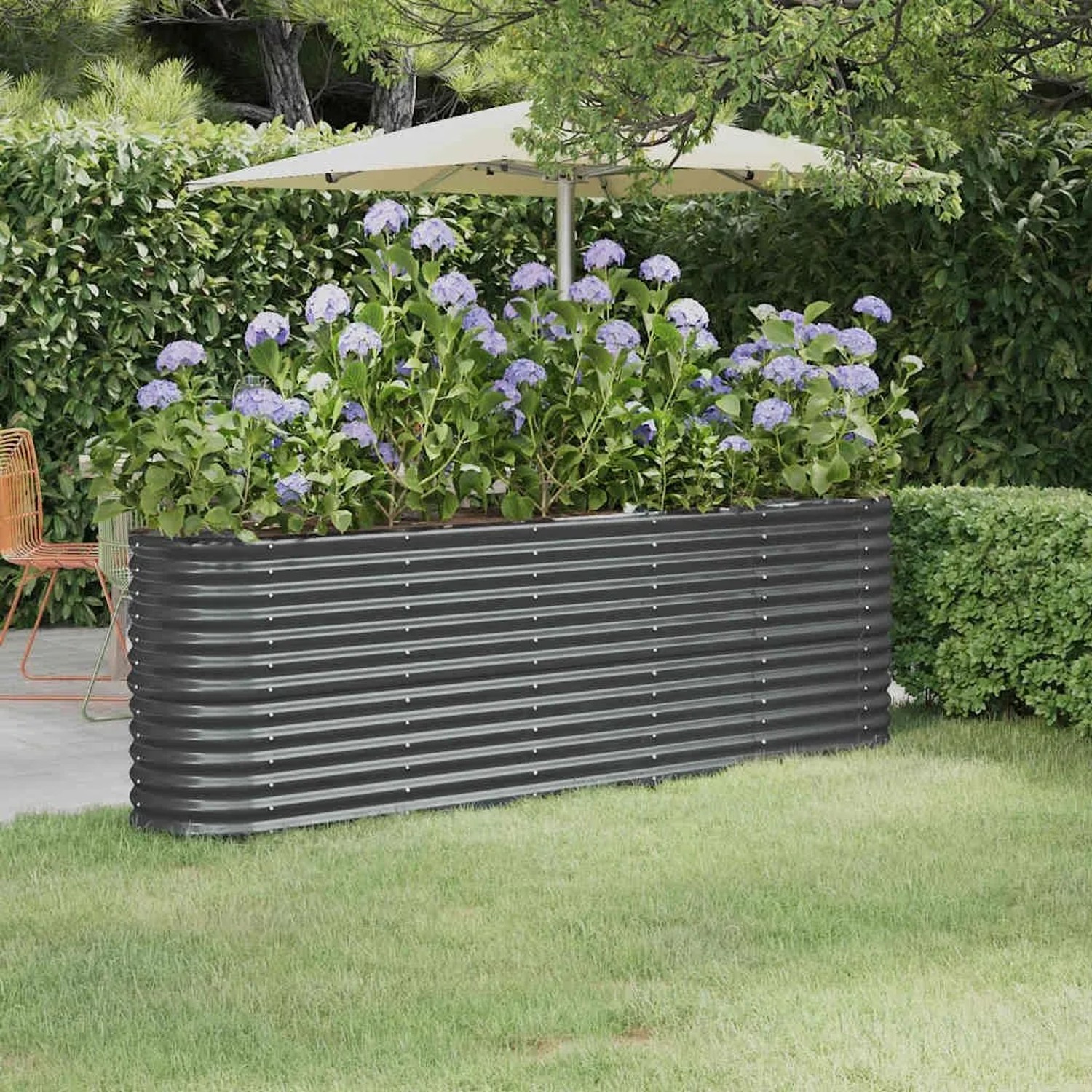 Anthrazitfarbenes Furnicato Hochbeet aus verzinktem Stahl, 224x40x68 cm, mit Bepflanzung im Garten.