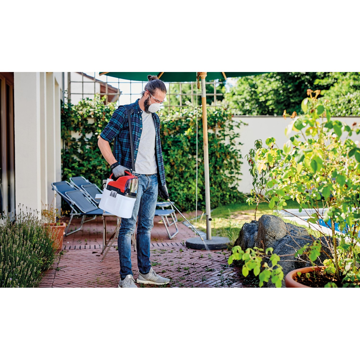 Mann nutzt Einhell Akku-Drucksprühgerät GE-WS 18/75 Li-Solo im Garten zur Pflanzenpflege.