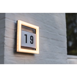 Quadratische LED Hausnummernleuchte Alice mit Rahmen und Ziffernblatt, montiert an einer Wand.