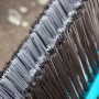 Gardena Straßenbesen Combisystem mit Holzstiel, Borsten in Grau und Braun, blaue Halterung.
