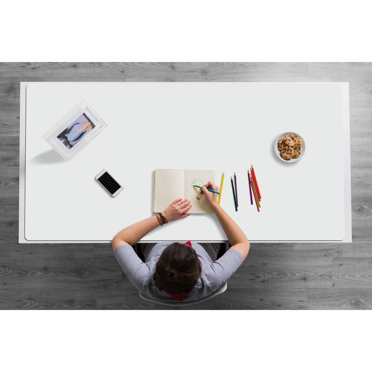 Person zeichnet auf hellgrauer Tulup Schreibtischunterlage. Die Deskpad schützt den Arbeitsplatz vor Kratzern und Flecken.