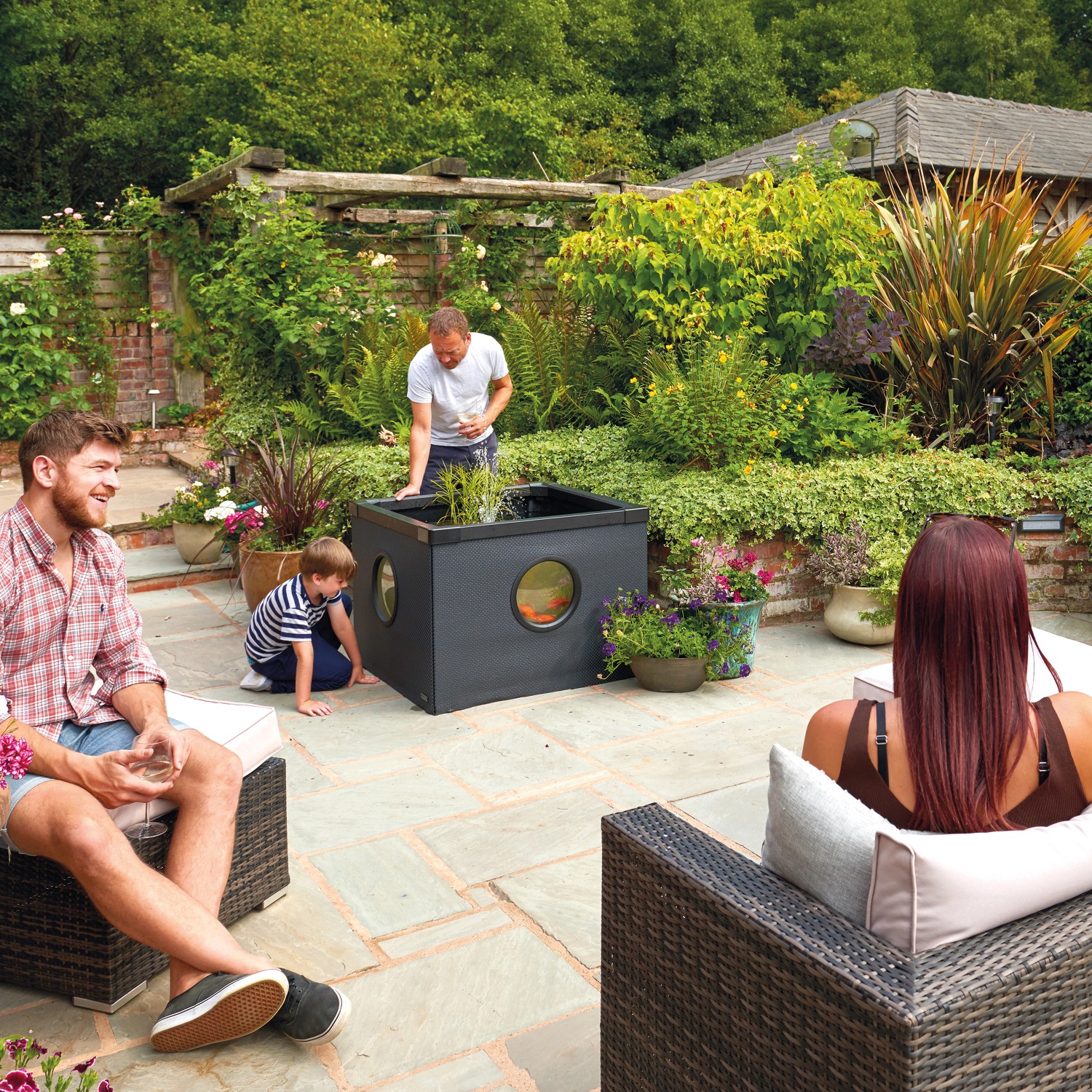 Hozelock Outdoor Aquarium 500 l im Garten mit Familie. Gartenaquarium mit Bullaugen.