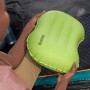 Grünes Bestway Air Pillow Wanderlite Camping-Kissen, gehalten in Händen vor Zelt.