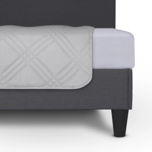 Detailaufnahme: Hellgraue Bestlivings Tagesdecke mit Steppmuster auf einem Bett.