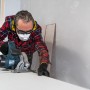 Handwerker mit 3M Peltor Gehörschutz X2A beim Sägen, effektiver Kapselgehörschutz für Heimwerker.
