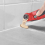 Einhell Multitool mit Schleifblatt im Einsatz zum Fliesenfugen entfernen.