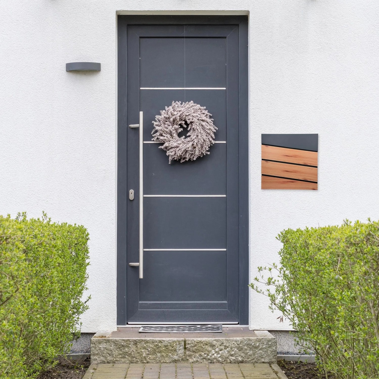 ML-Design Briefkasten in Anthrazit/Holzoptik mit Zeitungsfach an Hauswand.