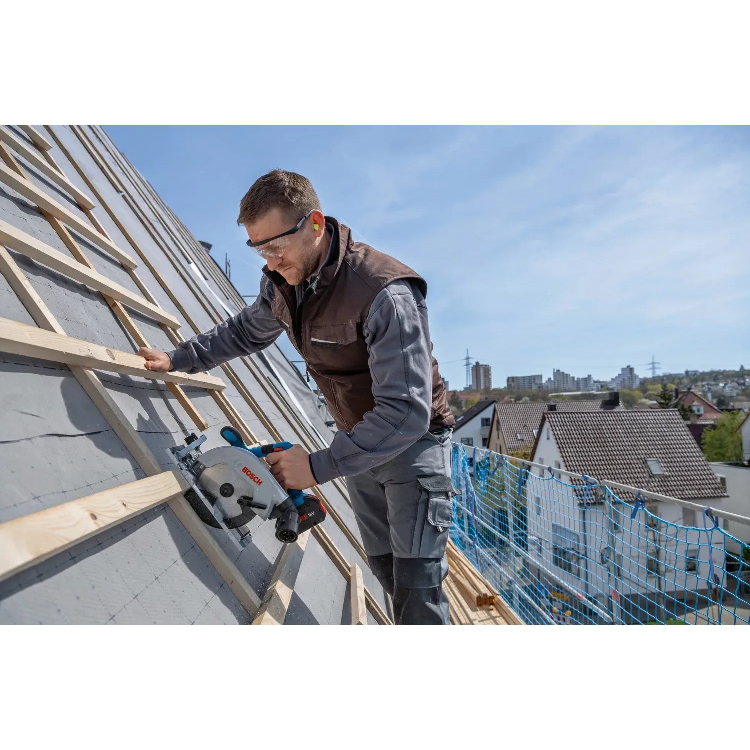 Bosch Professional Akku-Kreissäge GKS 18V-57-2 L Solo beim Sägen von Holz auf einem Dach.