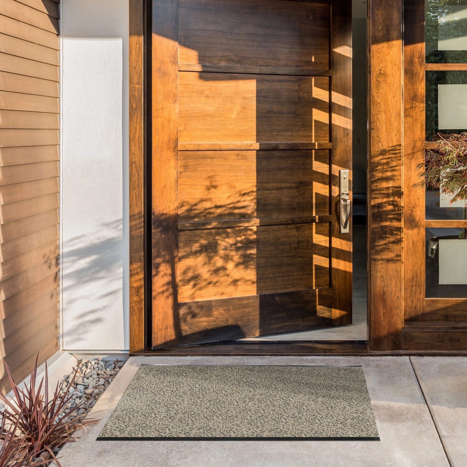 KARAT Schmutzfangmatte SKY, ocker-schwarz, 200x150 cm vor einer Haustür.