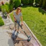 Frau reinigt Terrasse mit Gardena Akku-Multi-Reiniger AquaBrush Patio. Inkl. Akku.