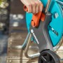 Gardena CleverRoll S Schlauchwagen-Set mit Hand beim Aufrollen des Gartenschlauchs.