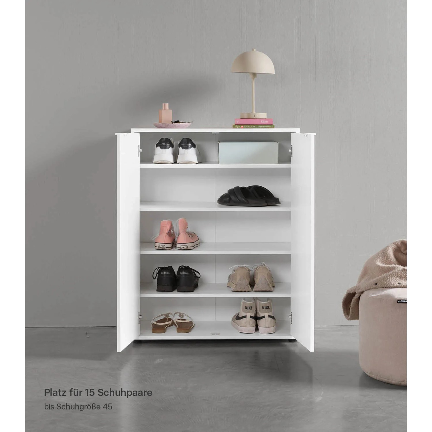 Weißer mokebo Schuhschrank "Der Concierge" mit zwei offenen Türen und mehreren Schuhpaaren.