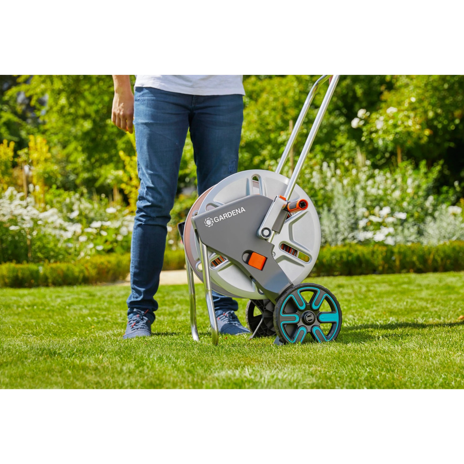 Gardena CleverRoll L Easy Metall Schlauchwagen auf Rasen, mit Person. Praktische Gartenbewässerung.