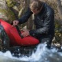 Mann repariert Kajak mit Tesa Reparaturband Ultra Power Under Water.