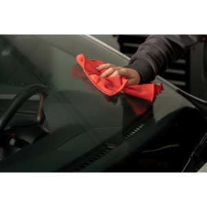 Nigrin Scheibenreiniger: Auto-Windschutzscheibe wird mit orangem Tuch gereinigt.