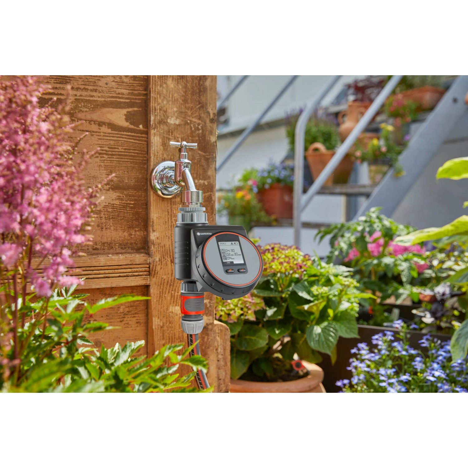 Gardena Bewässerungscomputer Flex am Wasserhahn mit Schlauch im Garten.