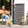 Arves Regentonne Norway 230 l dunkelbraun im Garten mit Frau, Katze und Dekoration.