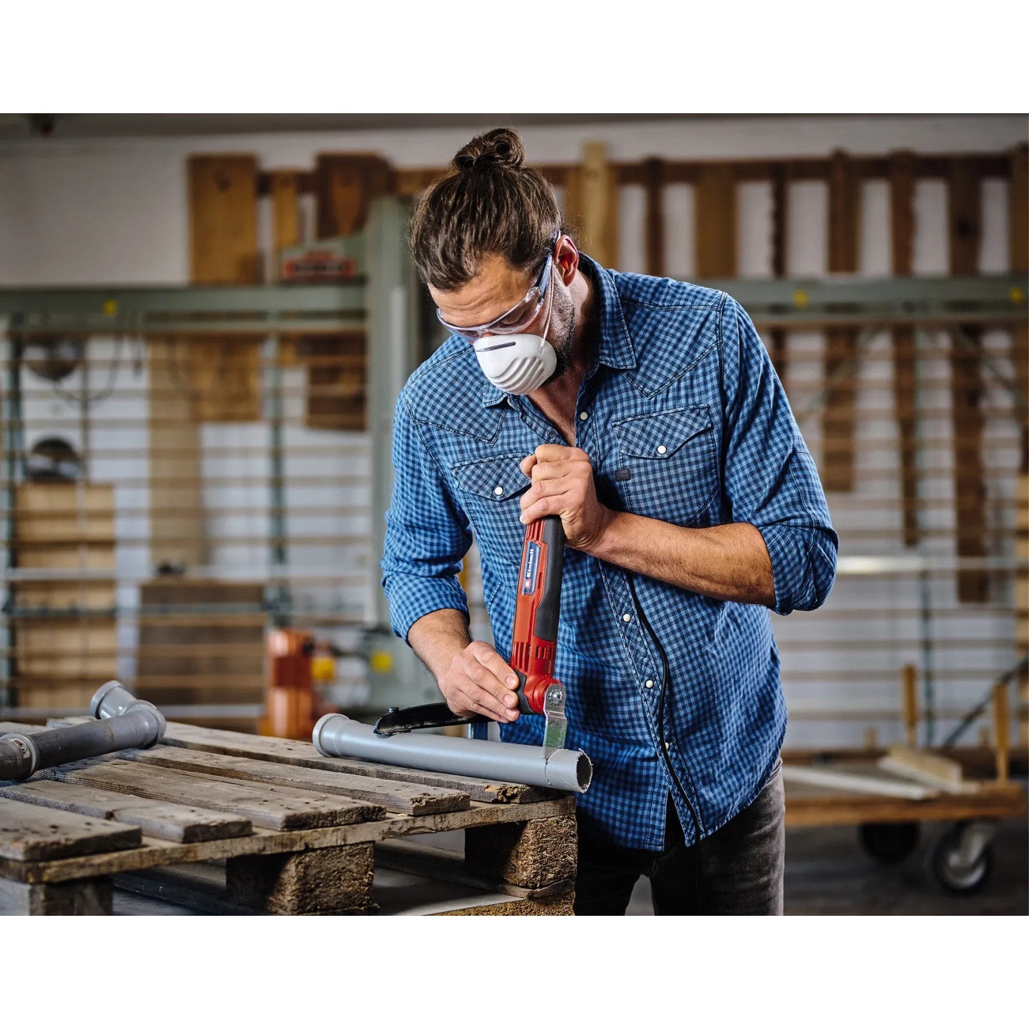 Mann schneidet Rohr mit Einhell Multifunktionswerkzeug TC-MG 250 CE. Multitool im Einsatz.