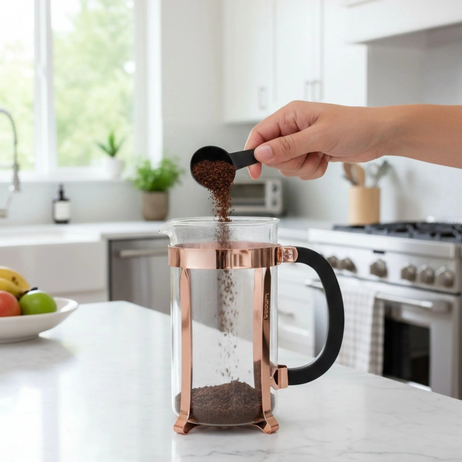 Hand gießt Kaffeepulver in Bodum French Press Kaffeebereiter 1,0l mit Kupferrahmen auf Küchenzeile.