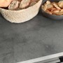 Detailaufnahme der grauen Arbeitsplatte der Respekta Küchenzeile Oliver 280 cm mit Brot und Snacks.