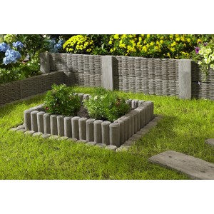 Beetbegrenzung mit Rundpalisaden-Randblock in Antik Holzoptik, eingefasst mit Rasen und Blumen.