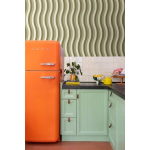 ESTAhome Vliestapete mit grünen und beigen Wellenstreifen in einer modernen Küche mit orangefarbenem Kühlschrank.