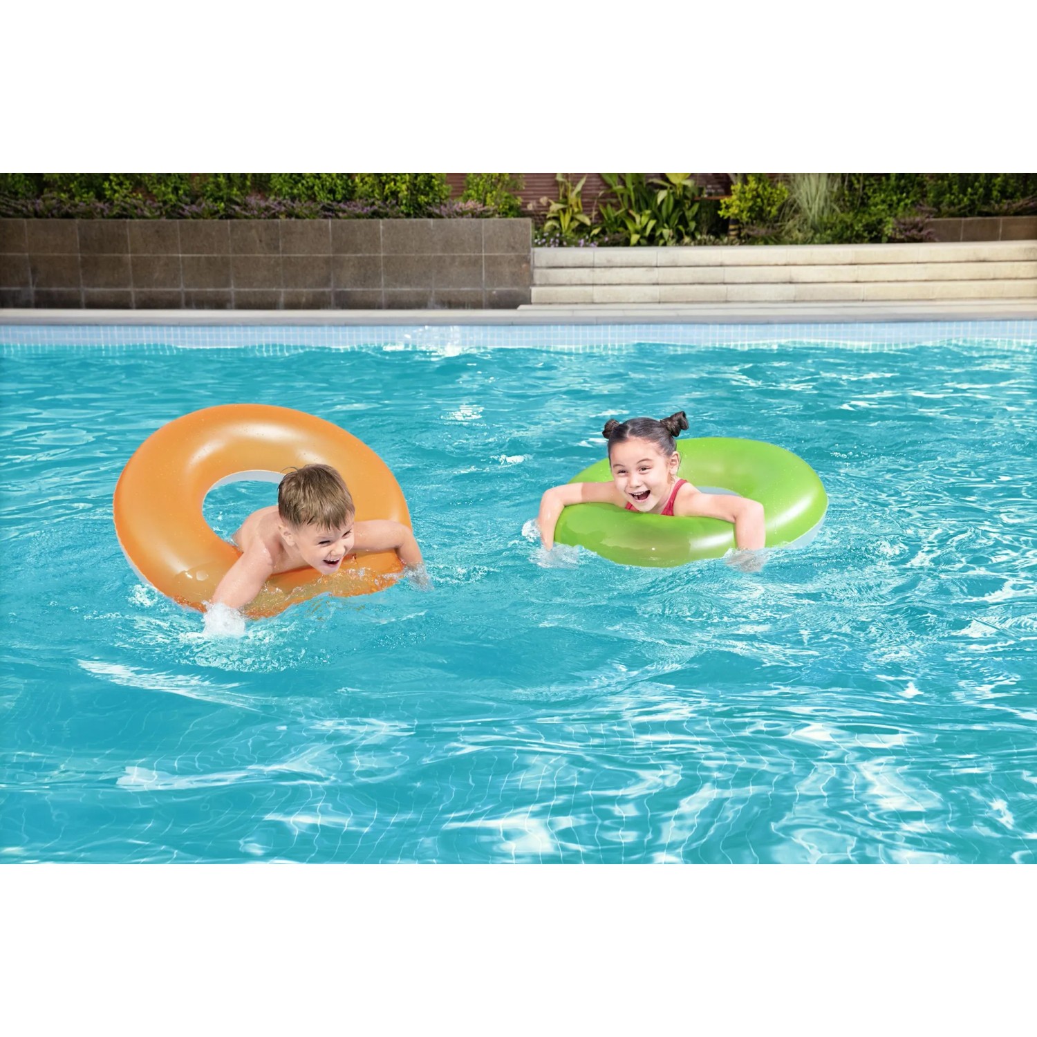 Kinder mit Bestway Schwimmringen (orange, grün) im Pool.