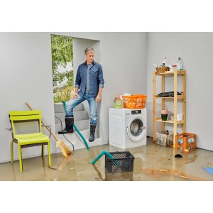 Mann mit Gardena Hochwasser-Set 10500 Basic im überfluteten Keller mit Pumpe, Schlauch und Box.