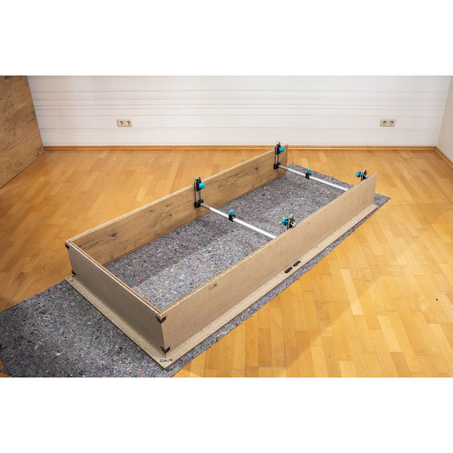 wolfcraft Türfutterstrebe Easy Spannwerkzeug stabilisiert eine Holz-Türzarge auf einer Schutzmatte für die Montage.