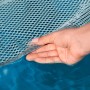 Detailaufnahme: Bestway Pool-Hängematte Comfort Plush im Wasser, Netzstruktur und Hand im Fokus.