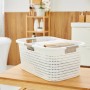 Weißer Rotho Wäschekorb Country (40 l) mit Rattanstruktur und Tragegriffen im Badezimmer.