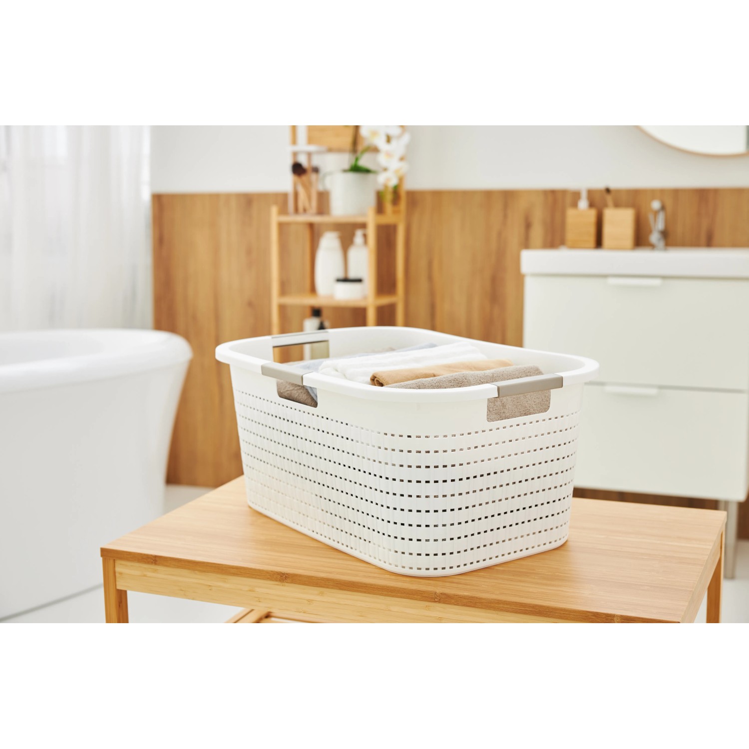 Weißer Rotho Wäschekorb Country (40 l) mit Rattanstruktur und Tragegriffen im Badezimmer.